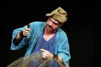 Male actor dressed as fisherman with fishing net