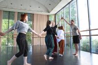 5 students holding hands in a row, doing movement work in an acting class