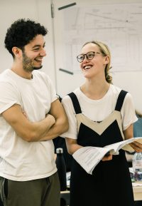 Two acting students in rehearsals, one holding a script