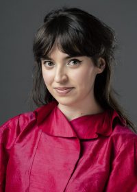 Headshot of girl in bright pin top with dark brown hair