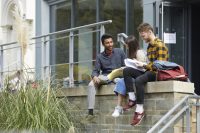 Three students sat on wall outside of BOVTS